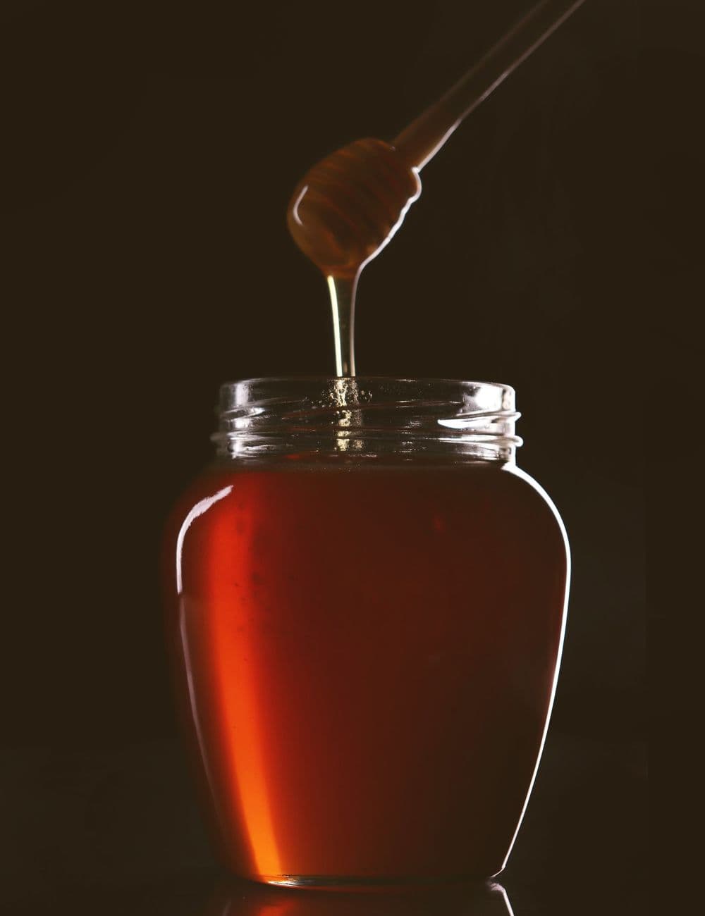 Honey poured against a dark ground