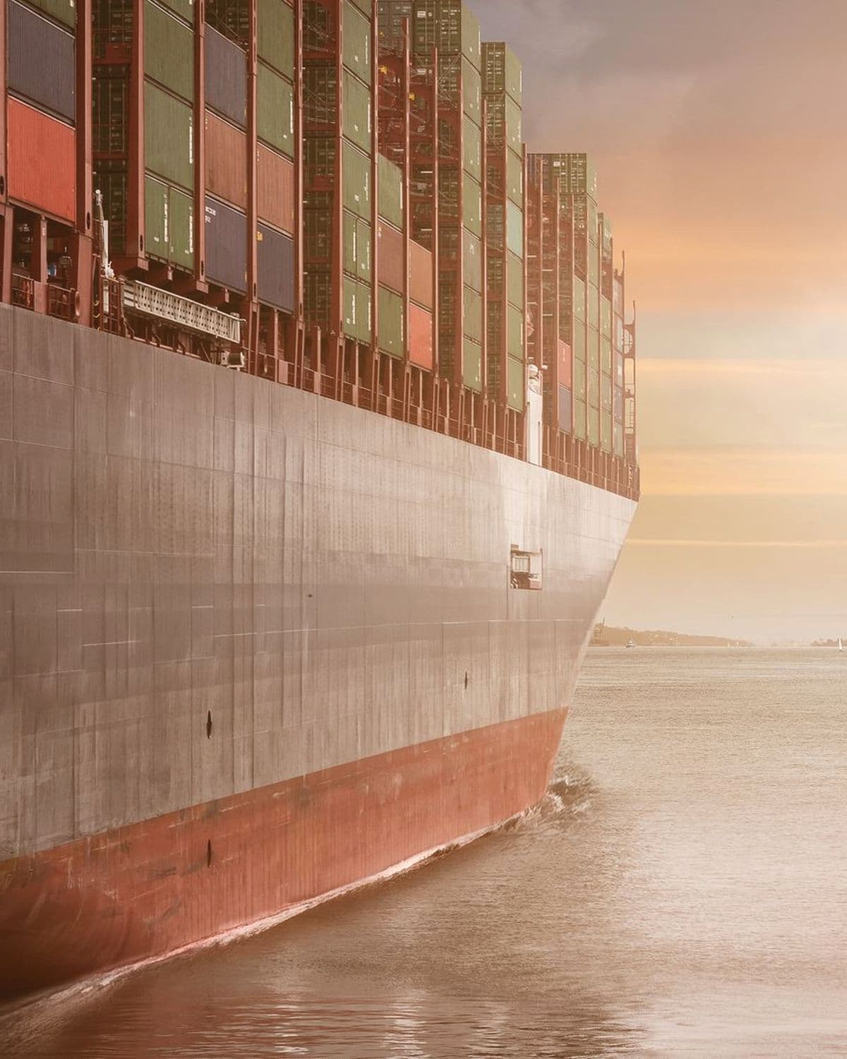 Bow of a loaded container vessel in low sun